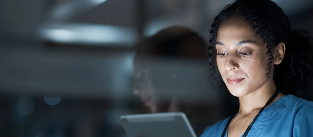 a nurse holding a tablet picking up nursing jobs nearby